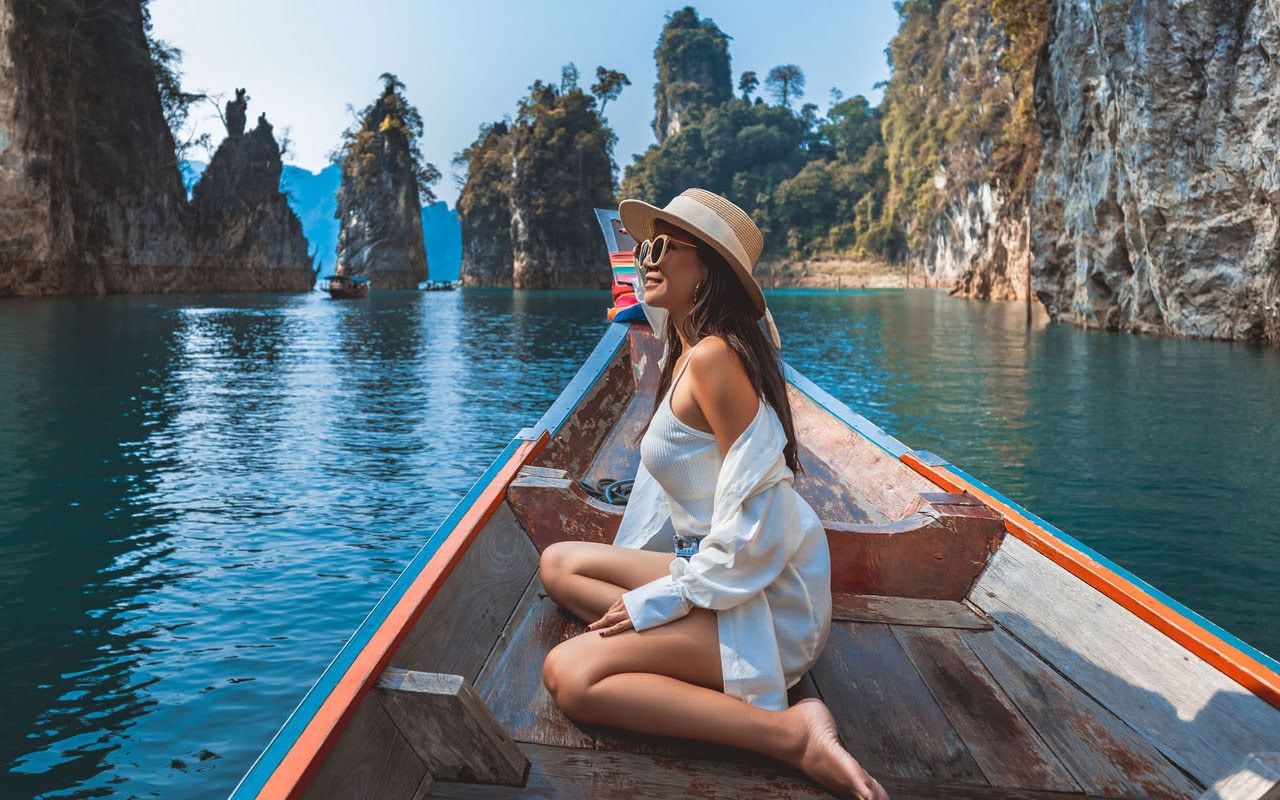 Een vrouw bekijkt de omgeving vanuit een bootje in Azië