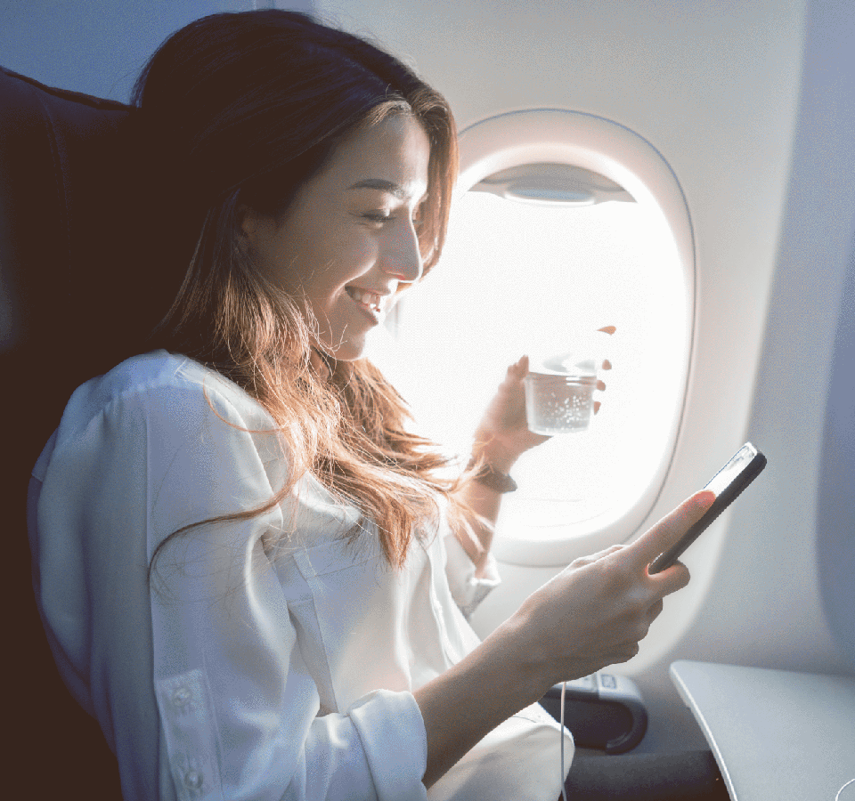 Een vliegpassagier bekijkt tevreden het Miles saldo op zijn smartphone
