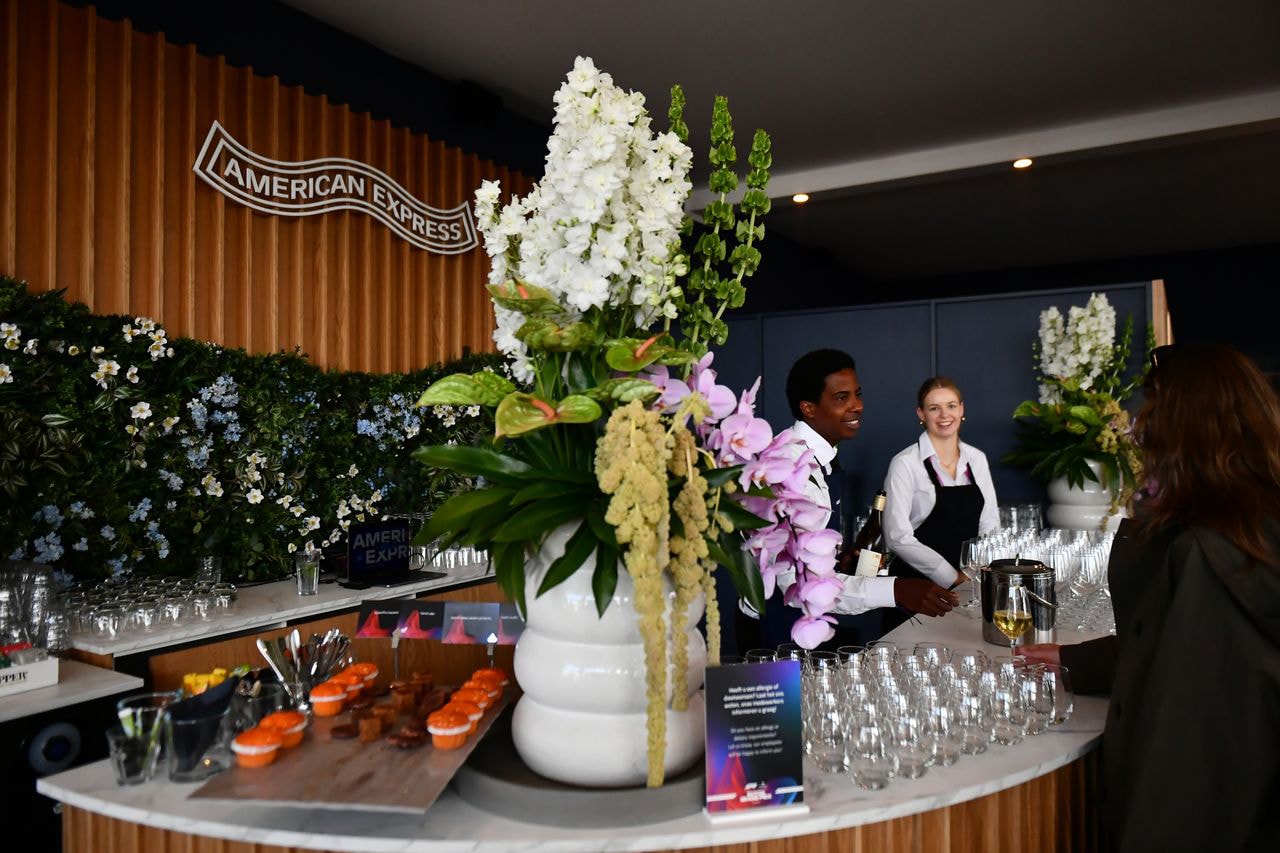 American Express private lounge bar with bites, glasses and flowers on top
