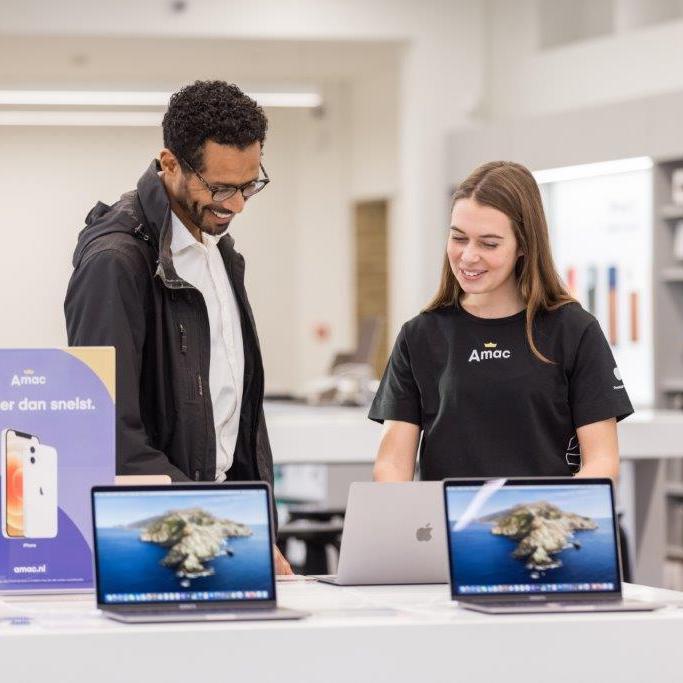 Image: Man en verkoopster bekijken een laptop in een Amac winkel