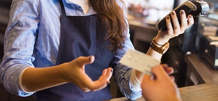 Woman in café accepting card payment