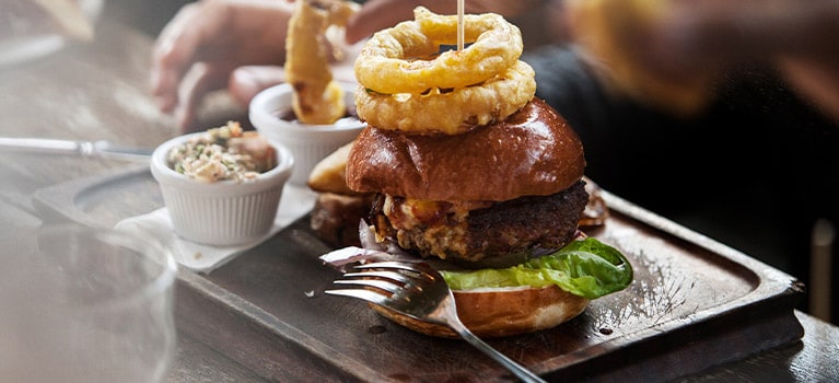 Prato com hamburguer e batatas fritas.