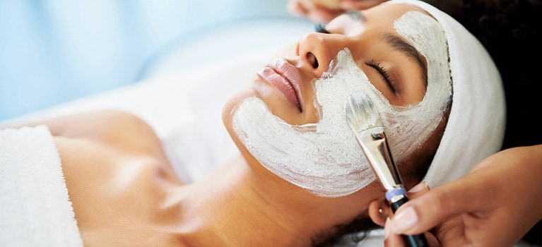 Uma mulher recebendo tratamento facial no spa.