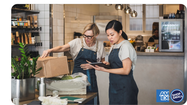 Small business owner holding bottle of wine and showing it to a customer