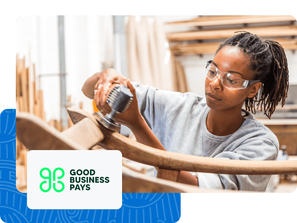  Good Buisness Pays logo is present next to a Merchant working in her workshop. 