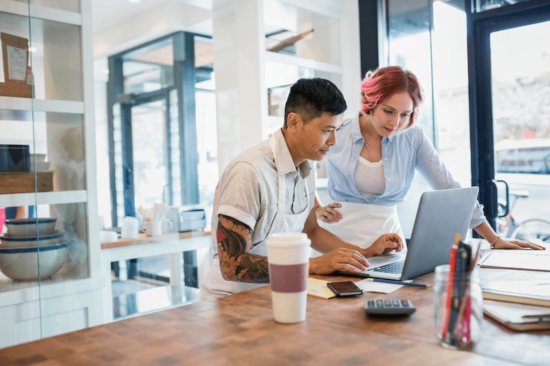 two merchants looking at laptop