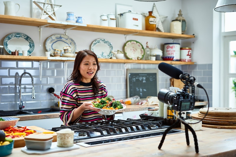 Food influencer in kitchen with video camera