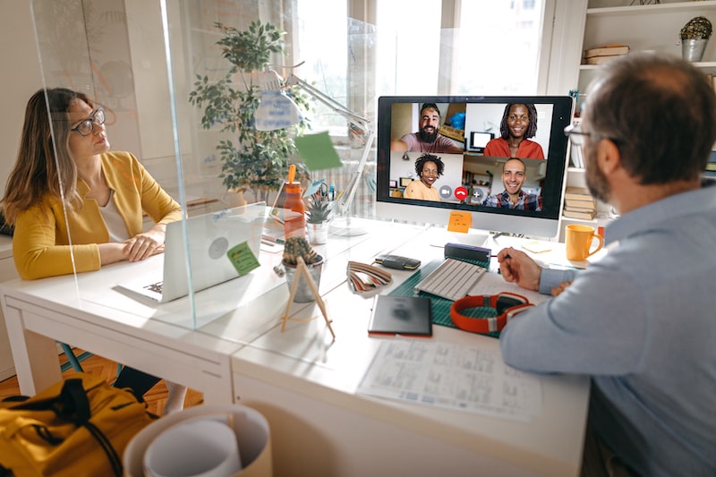 Two people at desks in apartment video conferencing