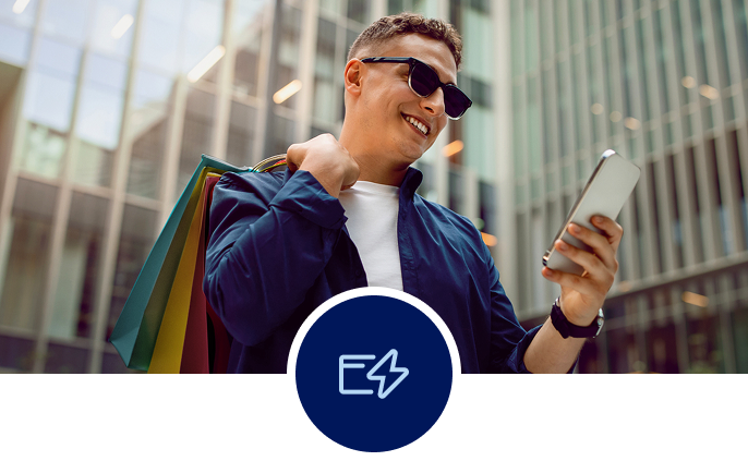 Man looking at his phone with city buildings in the background.