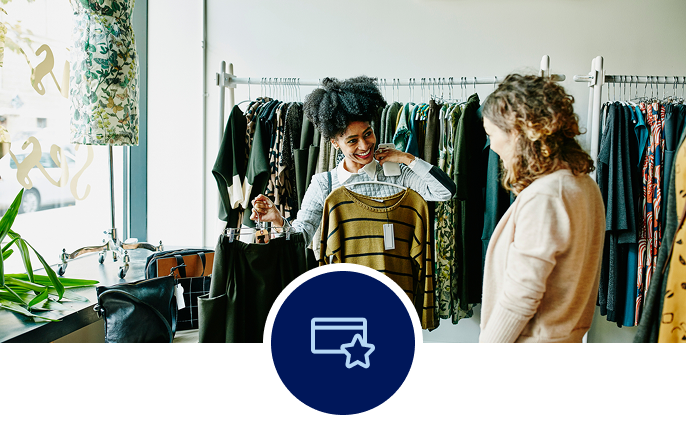 Two woman in a boutique store shopping for clothes.
