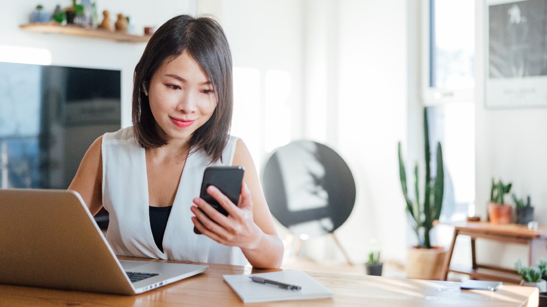 Person using laptop and holding mobile device