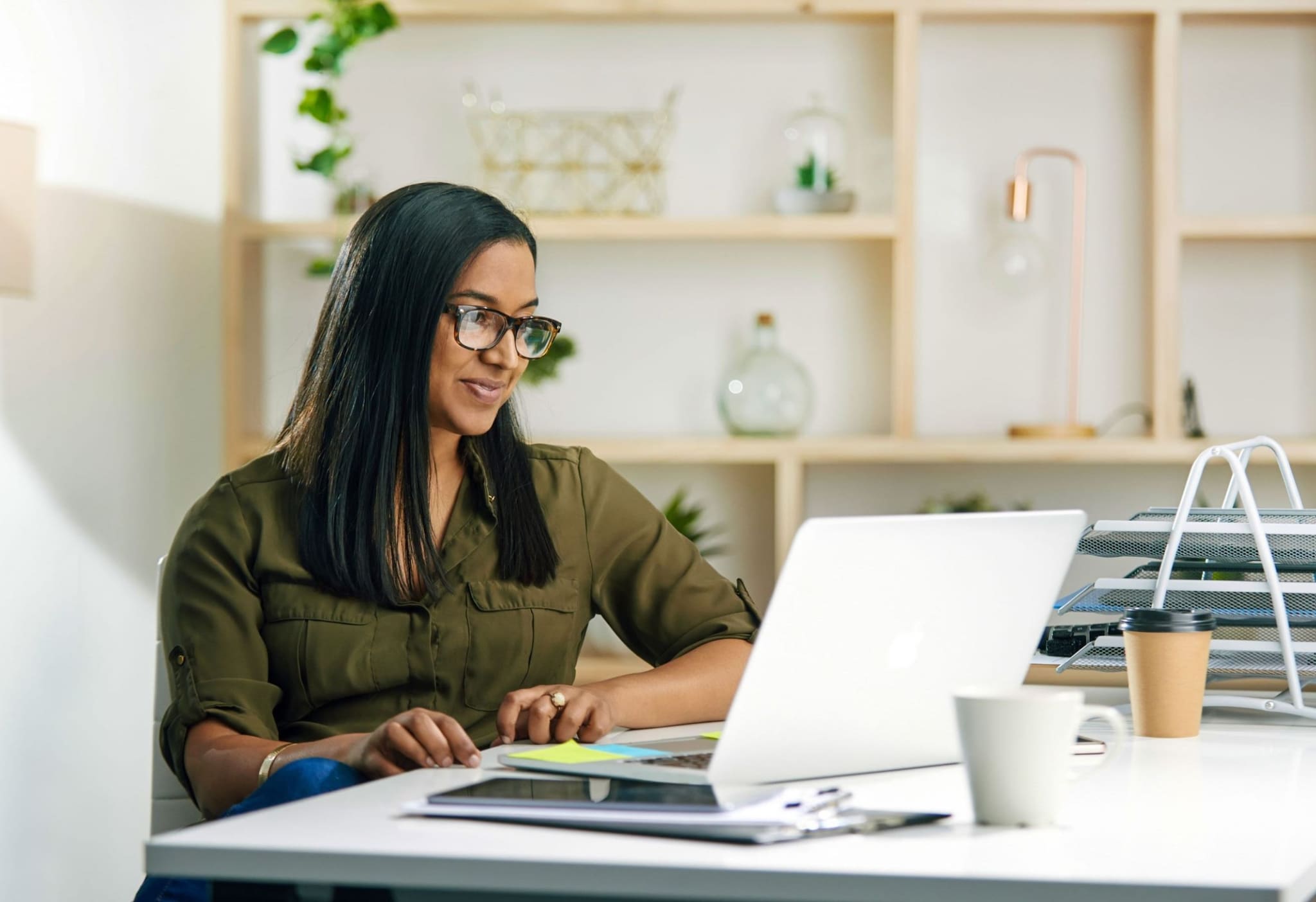 Young businesswoman working on a laptop in an office.