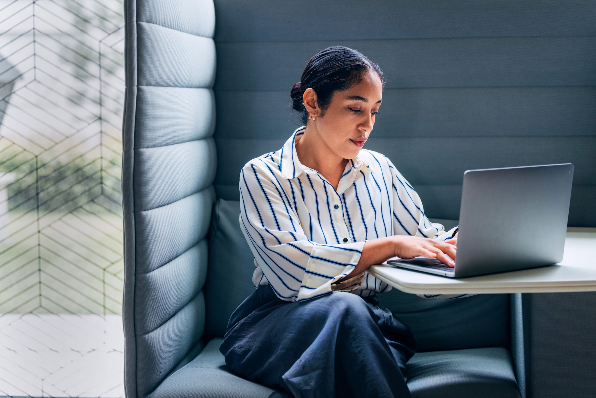A stylish business woman working independently on her laptop.