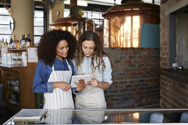 Two merchants looking at tablet device