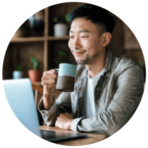 Person holding mug looking at laptop