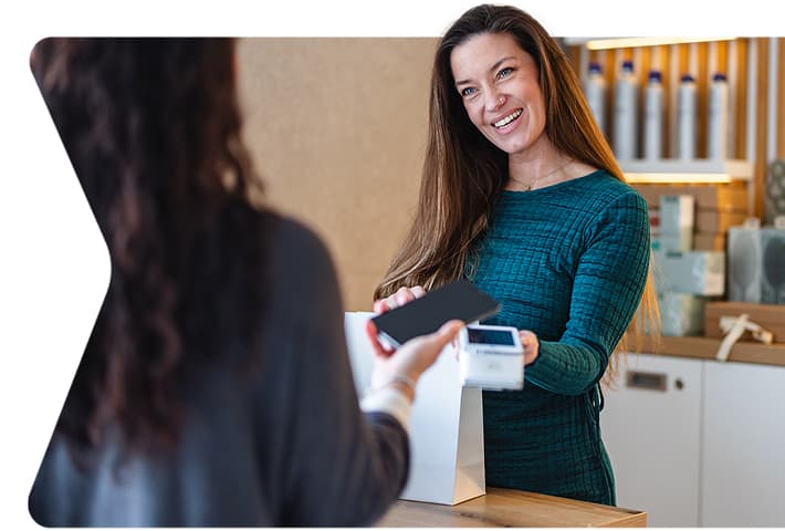 Shop owner taking tap-to-pay payment from a customer using their phone