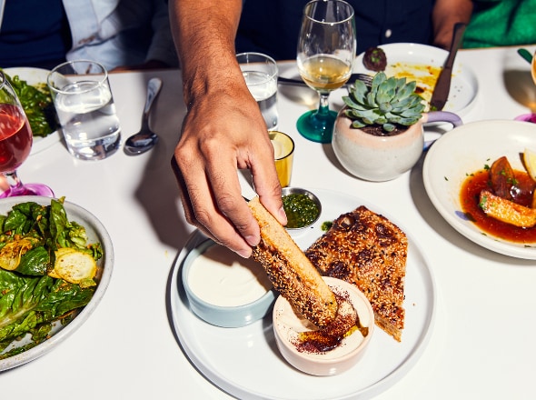 Person dipping food in a sauce