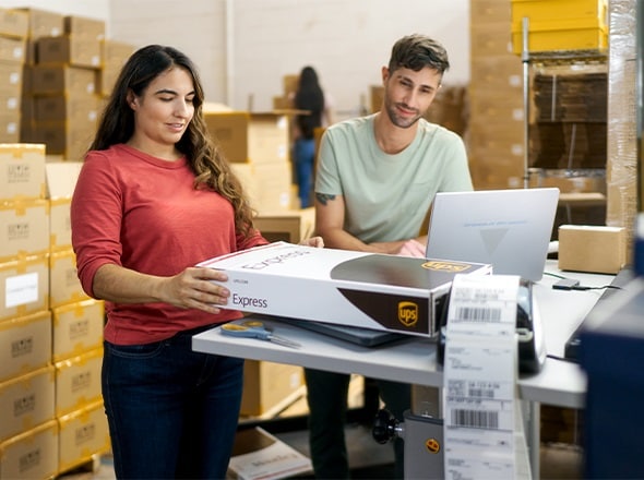 Man and woman packing a UPS box