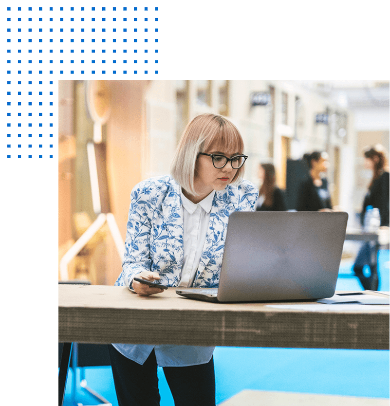 Woman gazes intently at her laptop in an open office
