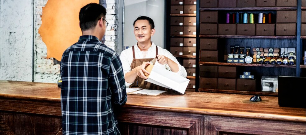 Business owner behind counter wrapping a purchase for a customer