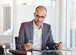 person sitting at desk looking at phone