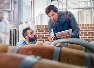 Two business owners talking and looking at tablet