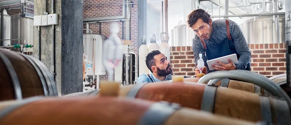 Two business owners talking and looking at tablet