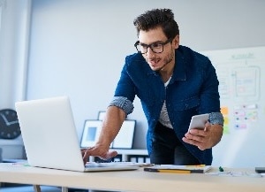 Person sitting at desk looking at phone