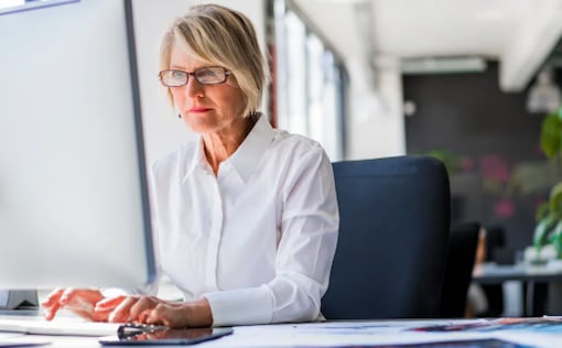 Woman sitting at desk looking at computer monitor