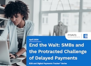 Woman standing at desk on laptop