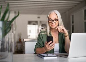 Person sitting at desk looking at phone