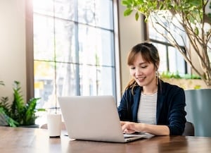 Woman sitting at desk looking at laptop