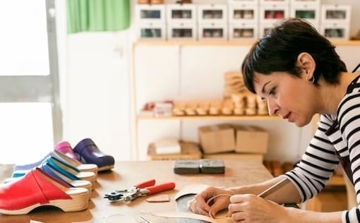 Woman at desk making shoes