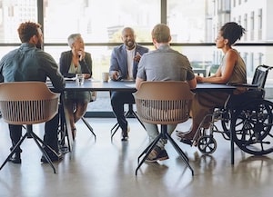 People sitting at a conference room table in an office