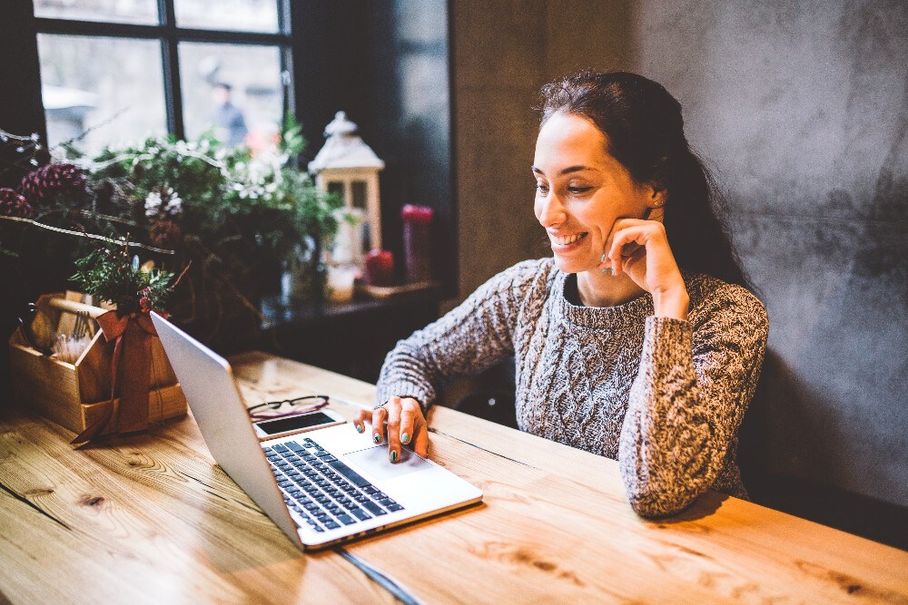 Woman sitting at desk and looking at laptop