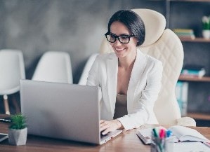 Person sitting at desk and looking at laptop