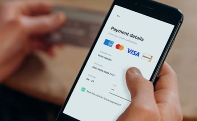 hand holding mobile phone showing payment screen