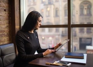 Woman sitting at desk looking at tablet