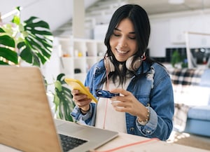 Woman on laptop looking at credit card