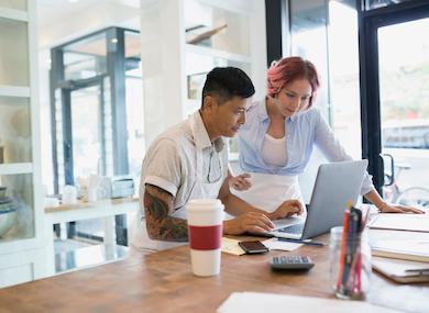 Two people looking at laptop in restaurant