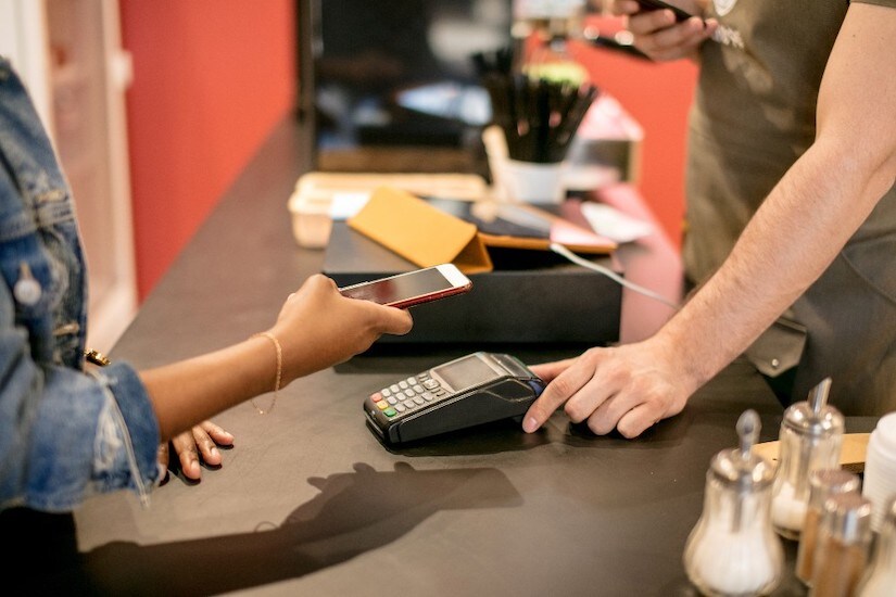 Person paying with phone at contactless terminal