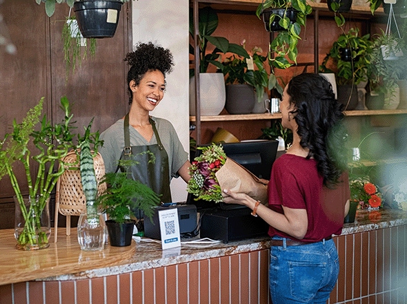 Customer at checkout in florist shop talking to the small business owner