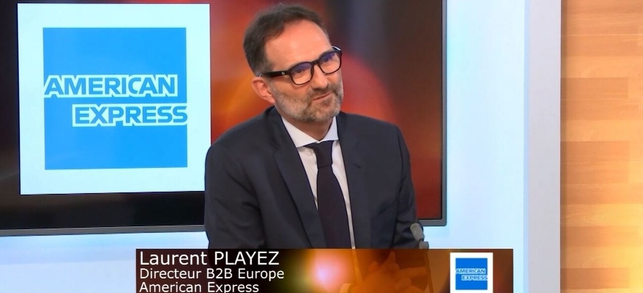 Personne travaillant d'un café. La journée est ensoleillée, une tasse et un laptop son posés sur la table devant elle.