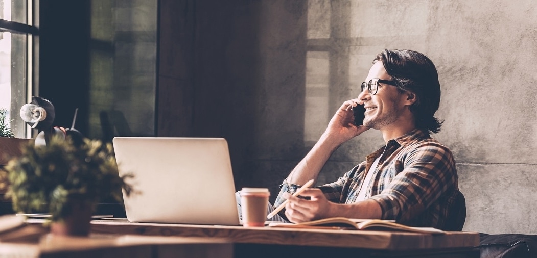 Homme assis à un bureau, au téléphone
