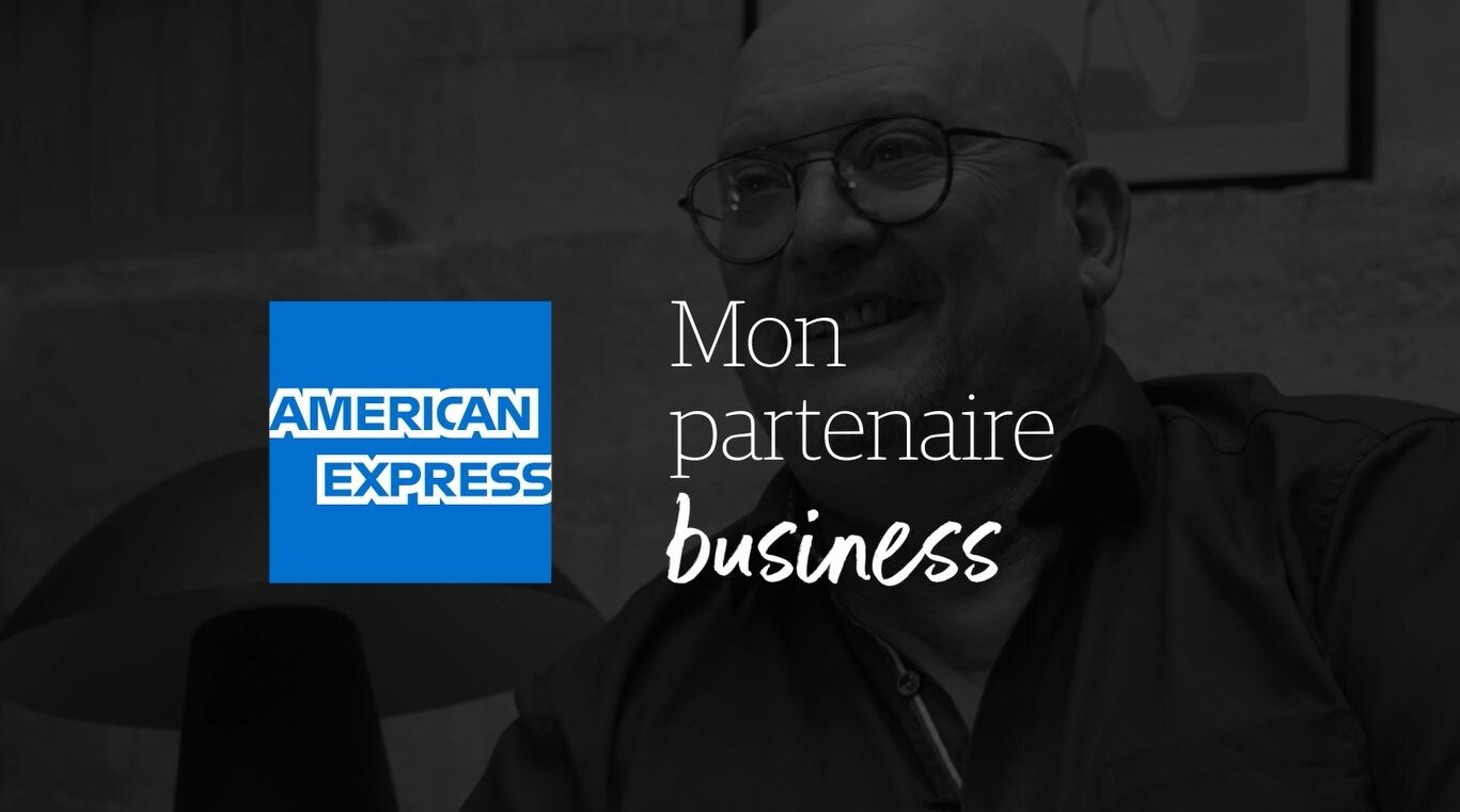 Trois personnes sont regroupées autour du comptoire d'une boutique lumineuse. Un enfant tend la main à celle située derrière le comptoire avec un sourire.