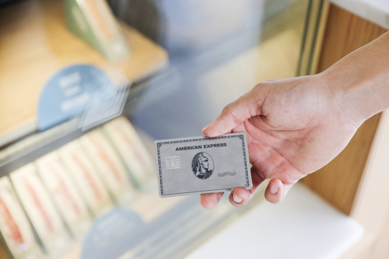 Eine Hand hält einen silberne American Express Kreditkarte