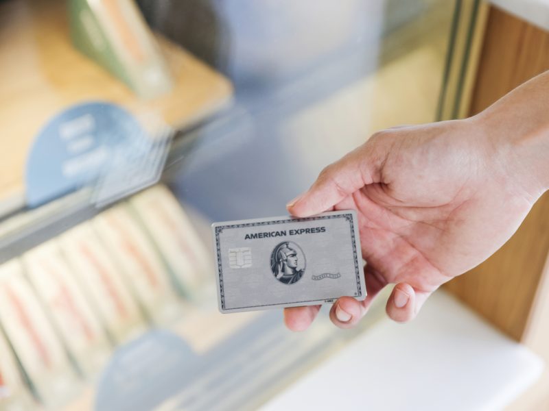 Eine Hand hält einen silberne American Express Kreditkarte