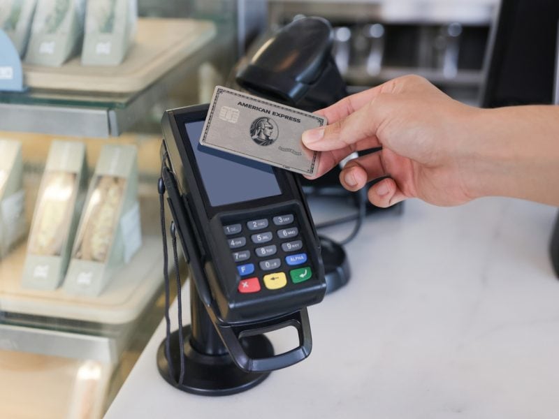 Eine Person benutzt eine Kreditkarte, um etwas zu bezahlen.
