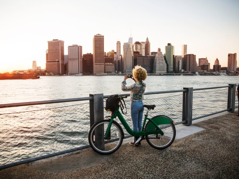 Eine Frau schaut auf die Stadt von einem Fahrrad aus.