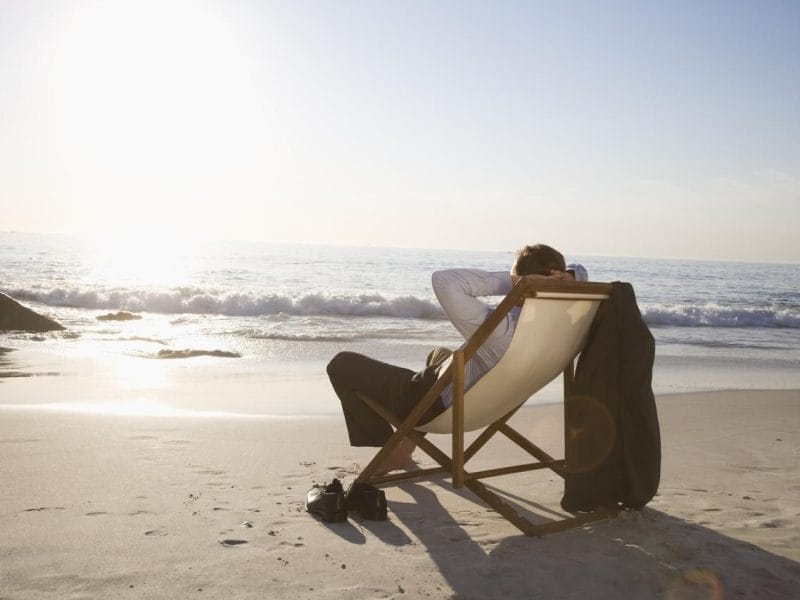 Pensionist entspannt in einem Liegestuhl am Strand